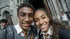 Two smiling students in Hogwarts-style robes and ties take a selfie outside a stone building.