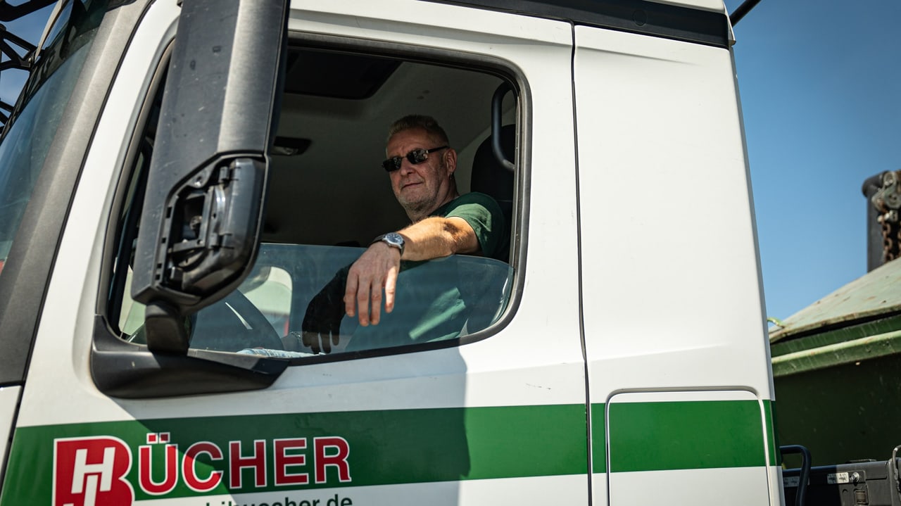 Berufskraftfahrer von Bücher im Fahrerhaus eines Containerfahrzeugs