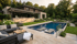 Modernes Haus mit Pool, Terrasse und Gartenlandschaft am Abend.