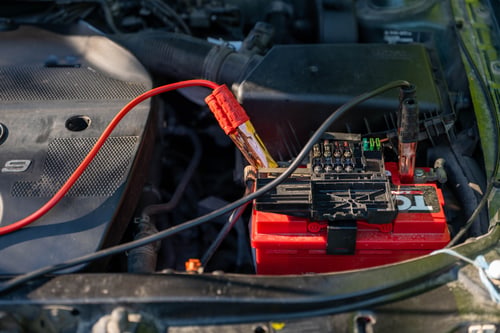Car battery with jumper cables attached on a cold winter morning in Cuyahoga Falls