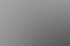 Ein lächelnder Mann im grauen Hemd und eine Frau sitzen an einem Konferenztisch in einem Büro mit Wandbildern.