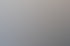 Eine junge Frau im Blazer lächelt am Tisch in der Büroküche.