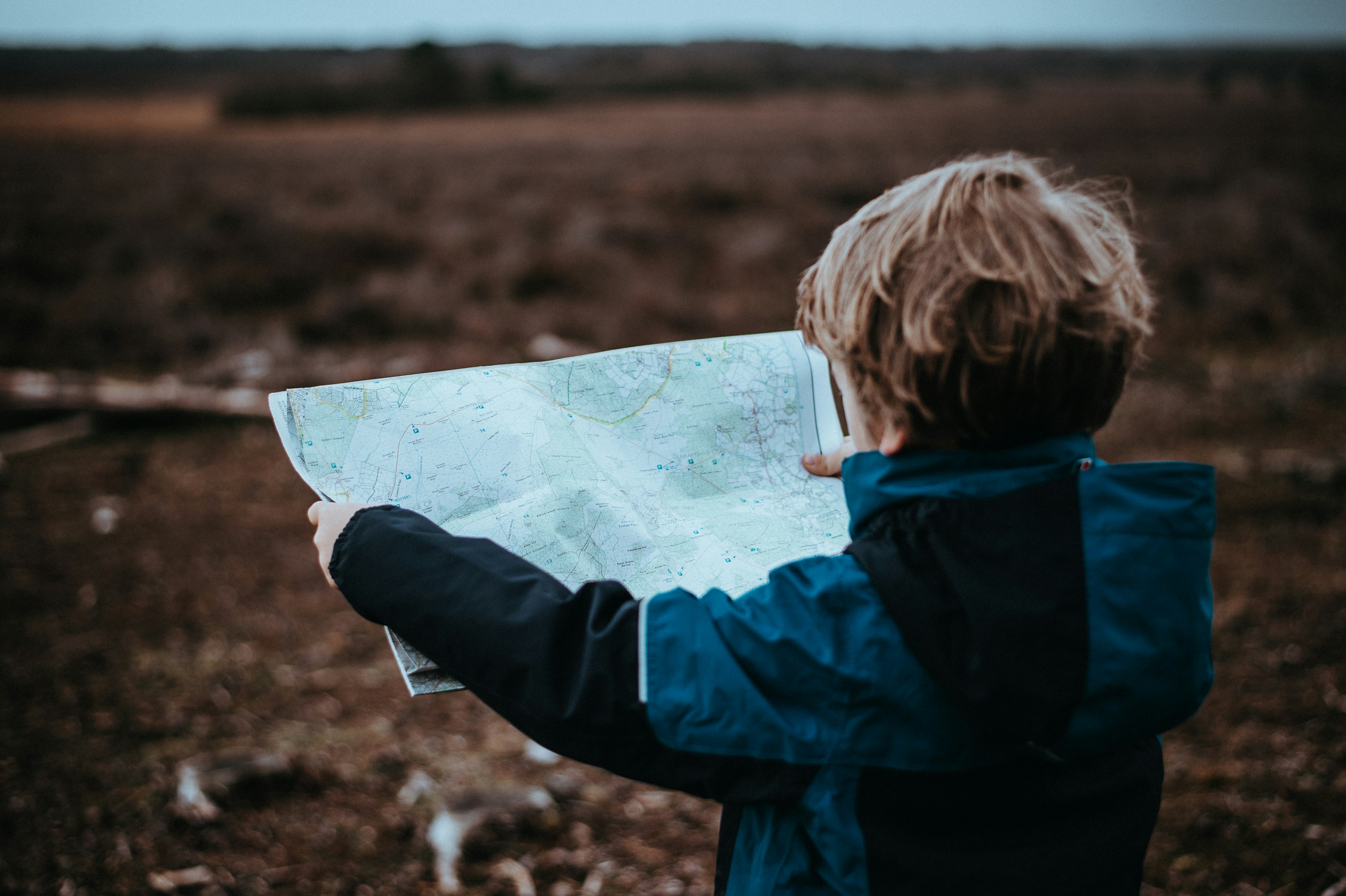 Kind liest eine Landkarte in der Natur