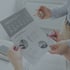 Zwei Personen halten ein Dokument mit Diagrammen zur Remote Work und zeigen mit Stiften auf verschiedene Statistiken.