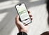 Hand hält Smartphone mit geöffneter Mitarbeiter-App, die den Text "Mehr Orientierung für Mitarbeiter, weniger Aufwand für HR" anzeigt.