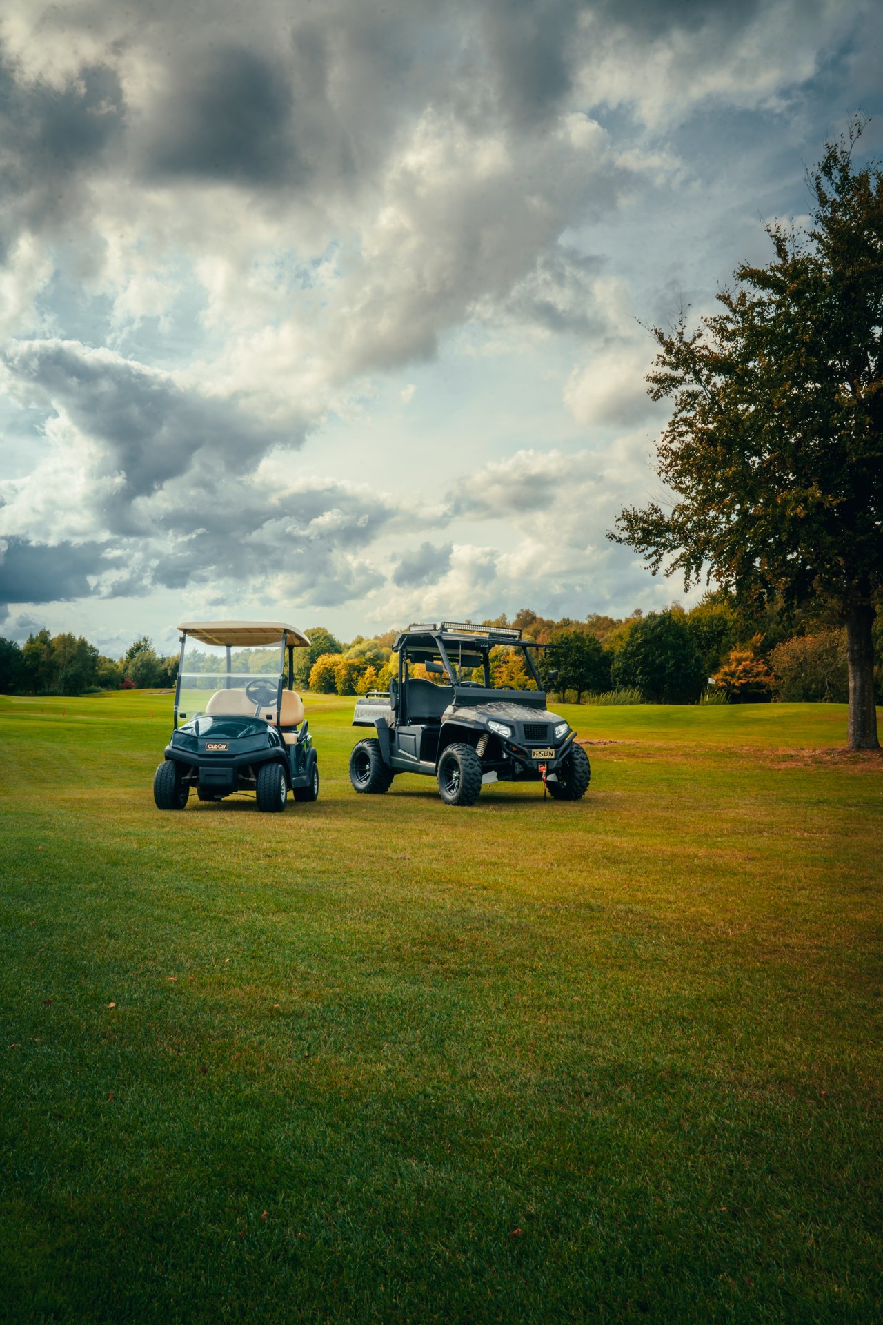 Golfwagen und Geländefahrzeug auf einem Golfplatz