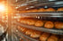 Frisch gebackene Brotlaibe kühlen auf einem spiralförmigen Förderband in einer industriellen Bäckerei ab.
