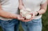 Katharina und Georg Rapberger in Jeans und hellen T-Shirts halten gemeinsam eine Handvoll frischer Kräuterseitlinge in ihren Händen.