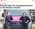 Zwei Frauen in schwarzen Pullovern lehnen an einem pinken Lieferwagen mit der Aufschrift „Beauty Truck“.
