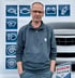 Ein Mann mit Brille und einem blauen Bosch Service Pullover steht vor einem Banner mit Auto-Icons und "BOSCH Service" Logo.