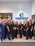 Integrated Medical Chiropractic & Wellness staff standing together in a clinic lobby under the company logo.