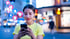 Young woman smiling, looking at her smartphone, with social media reaction icons floating around her.