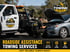 A Towing Eastvale technician inspects a car engine next to a tow truck..