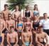 Eine Gruppe von Schwimmern und Trainern posiert im Freien.