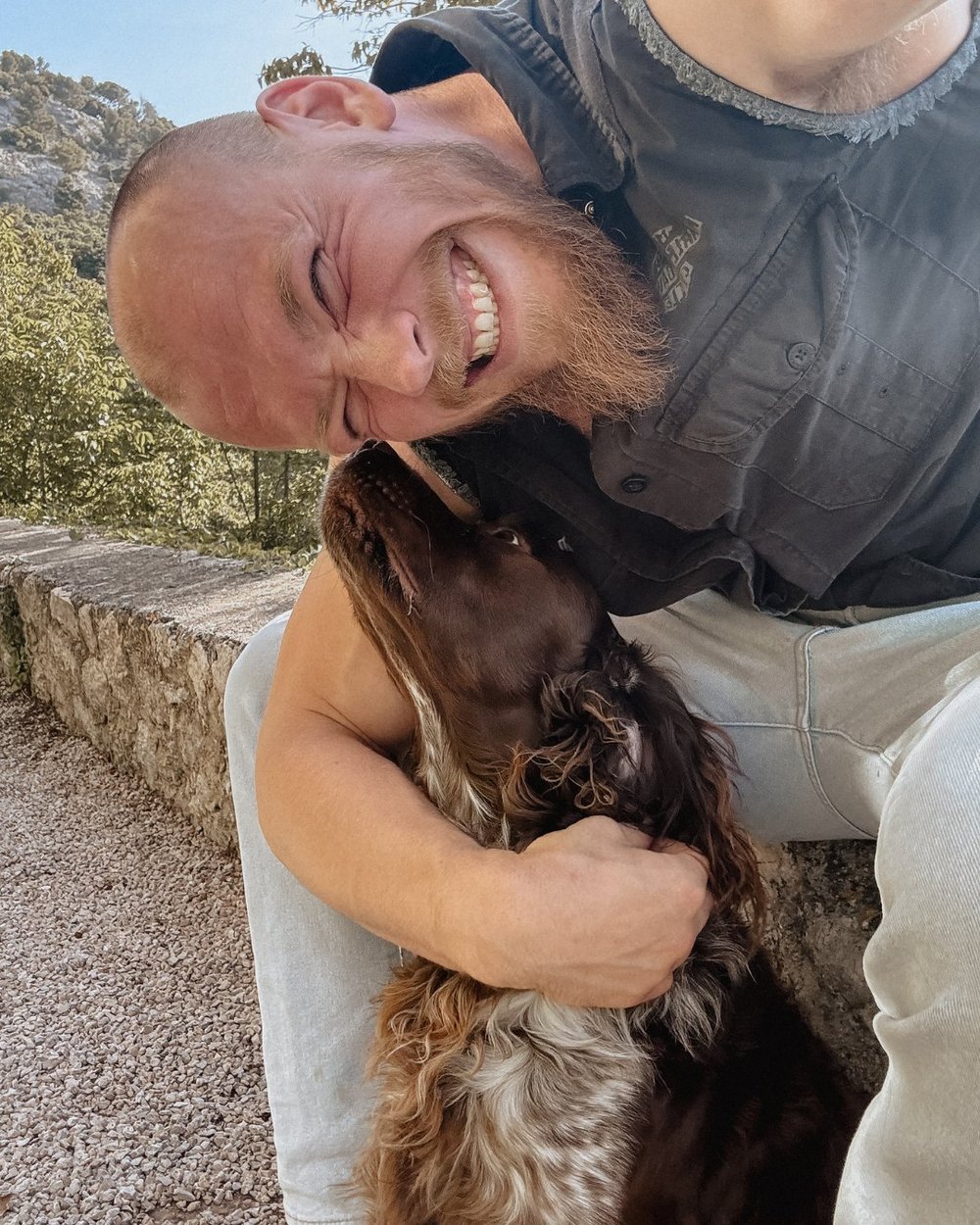 Mann umarmt einen braunen Hund