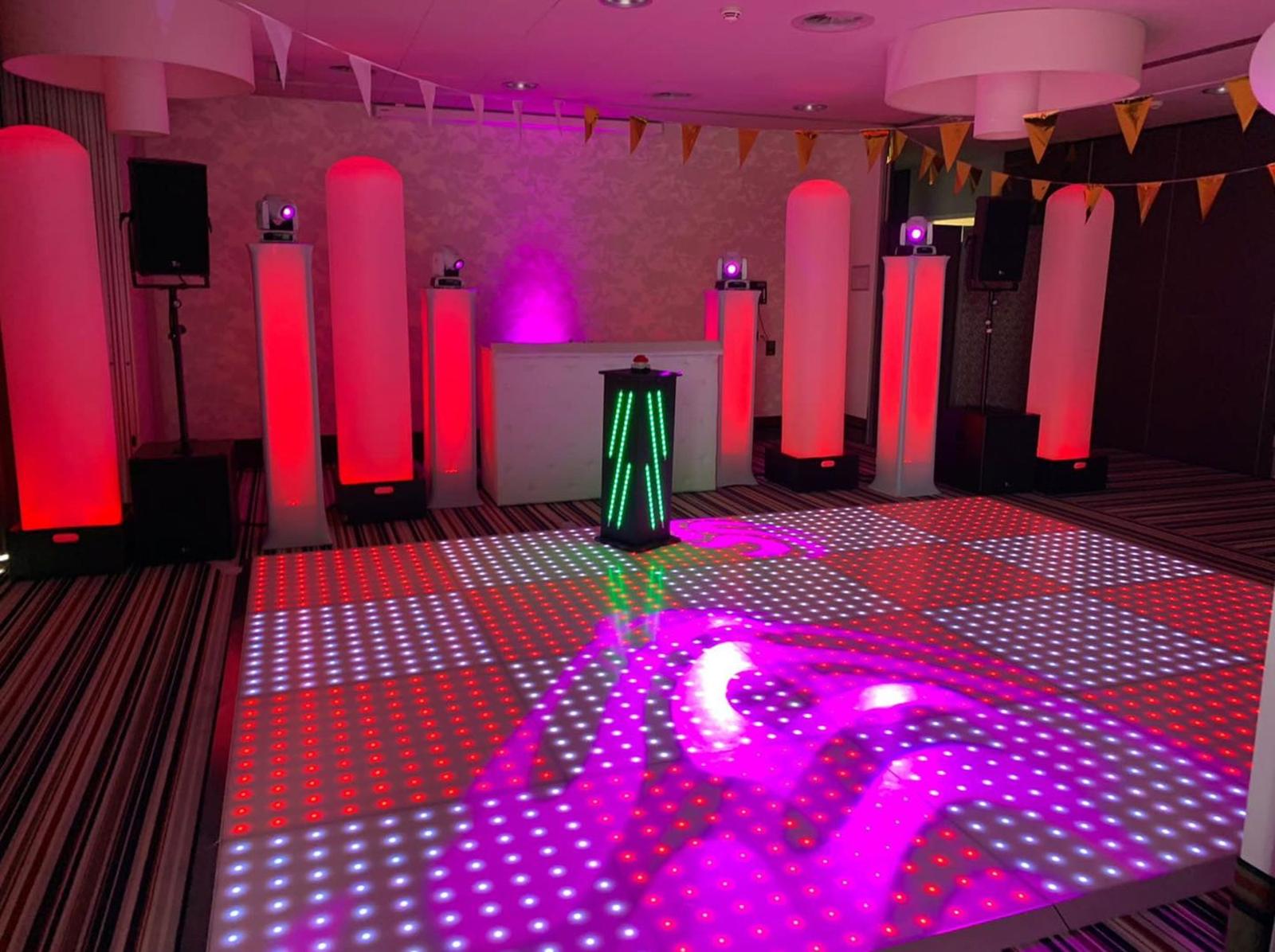 Lege zaal met lichtzuilen en verlichte dansvloer, opgebouwd door Superfuif