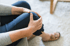 Person in blue pants holding knee, highlighting neuropathy pain treatment.