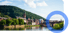 Heidelberger Altstadt mit Neckar, Alter Brücke und Heiliggeistkirche vor bewaldetem Hang unter blauem Himmel.