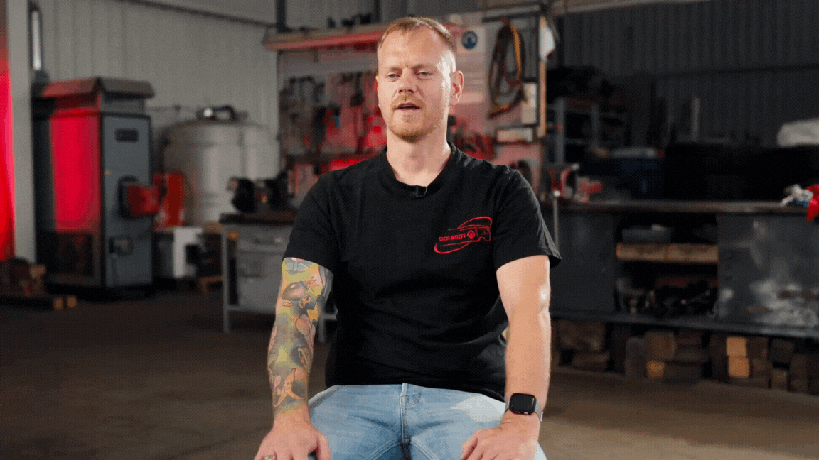 Mann, der in einer Werkstatt sitzt und spricht