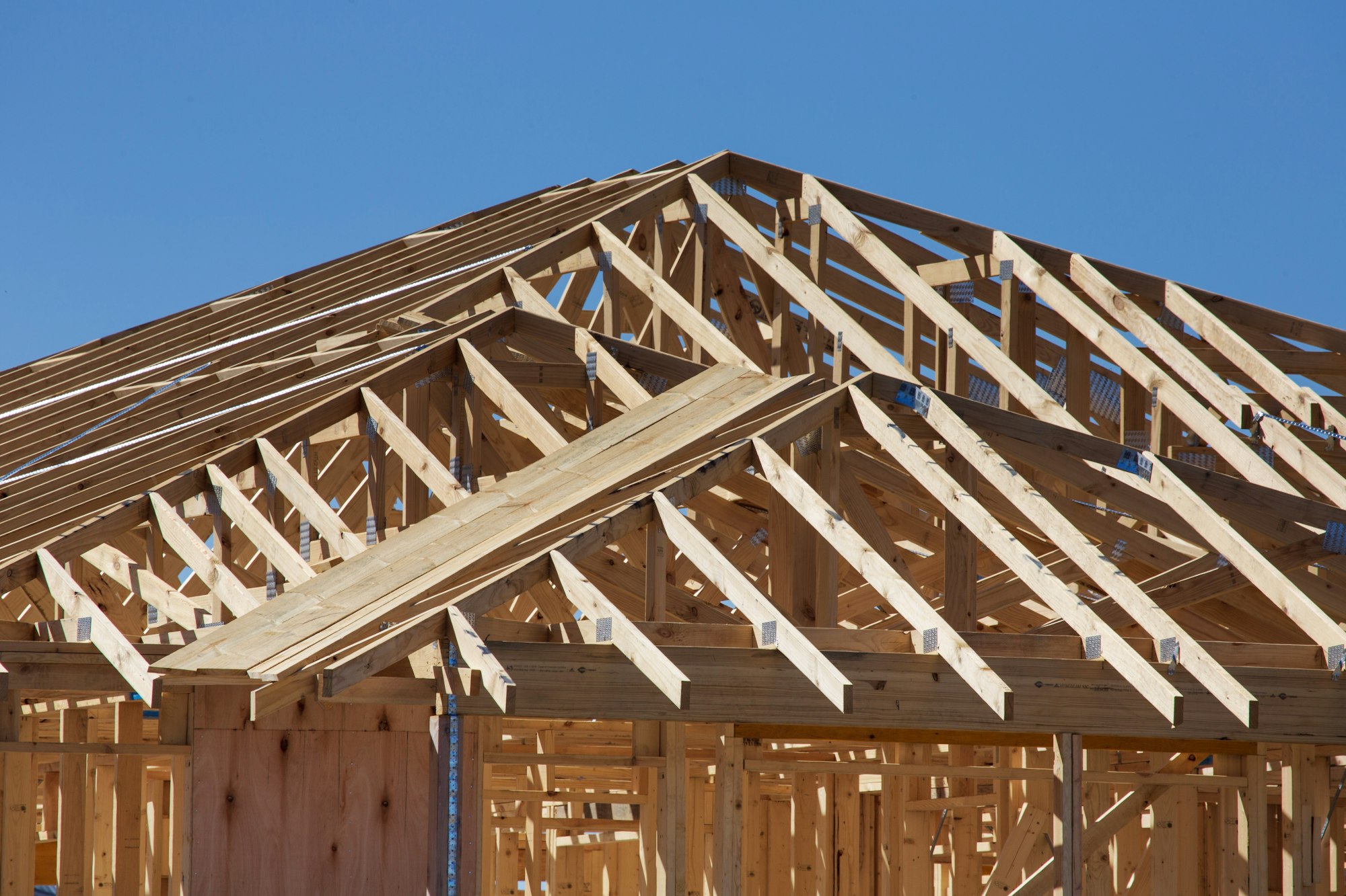 Exposed roof framing and decking on a house under construction, the point at which a permit is required to replace a roof in Fort Worth