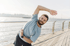 Man doing gentle stretching exercise for physical therapy by the water