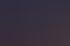 Ein Personal Trainer spricht mit einem Kunden an einem Rudergerät im Fitnessstudio.