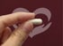 Hand holds a BioTE hormone replacement capsule against a heart-themed background.
