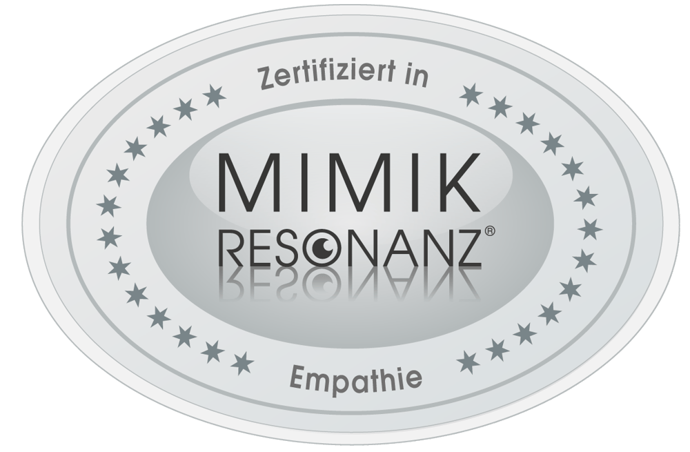 Silbernes, ovales Gütesiegel mit Sternenkranz: "Zertifiziert in MIMIK RESONANZ® Empathie".
