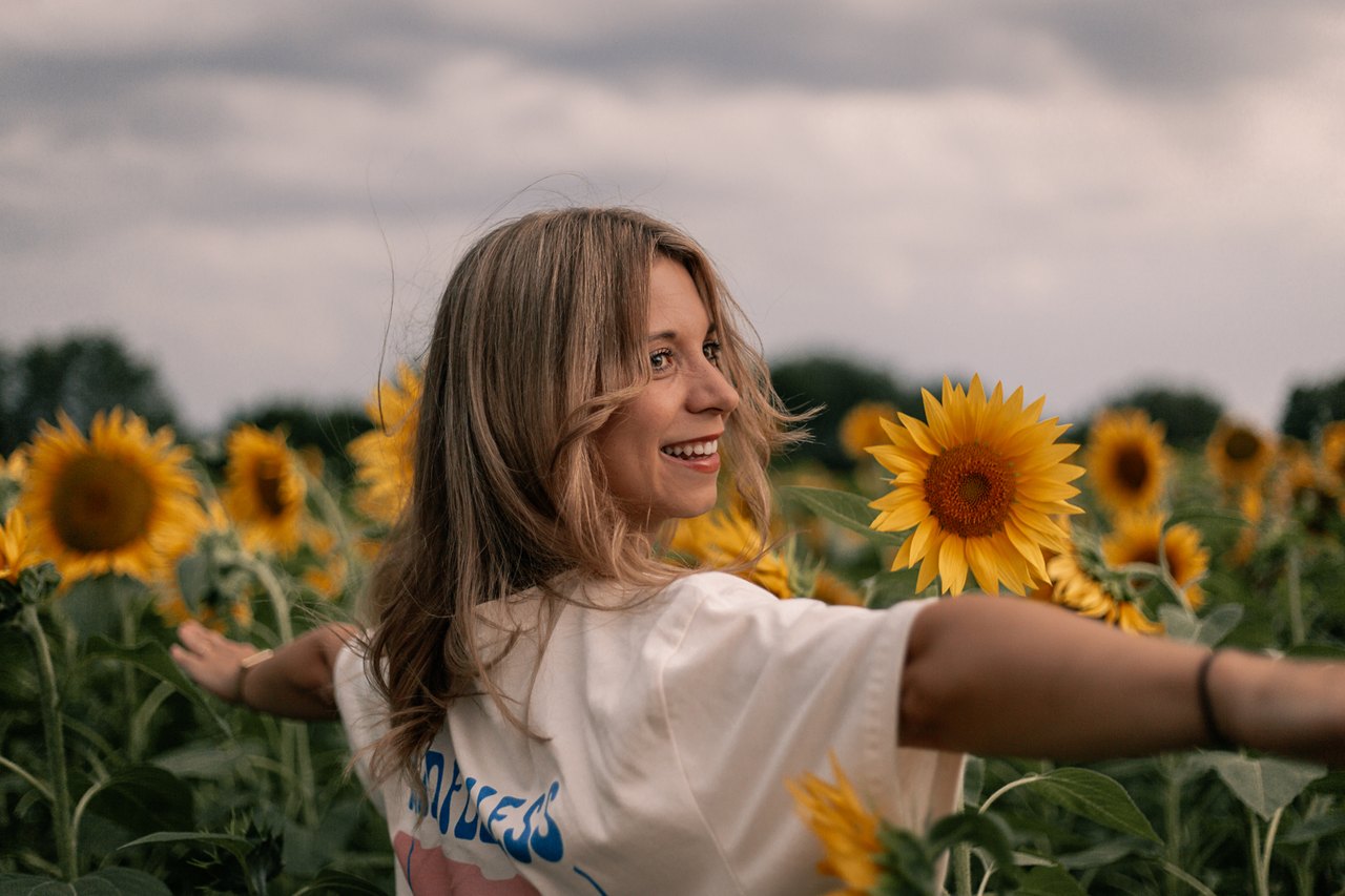 Julia lacht im Sonnenblumenfeld