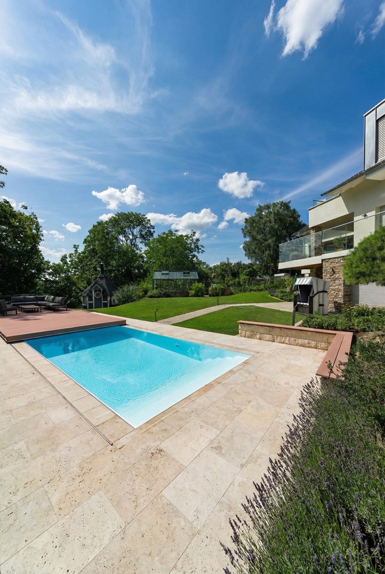 Pool mit hellblauem Wasser und beigefarbenen Fliesen