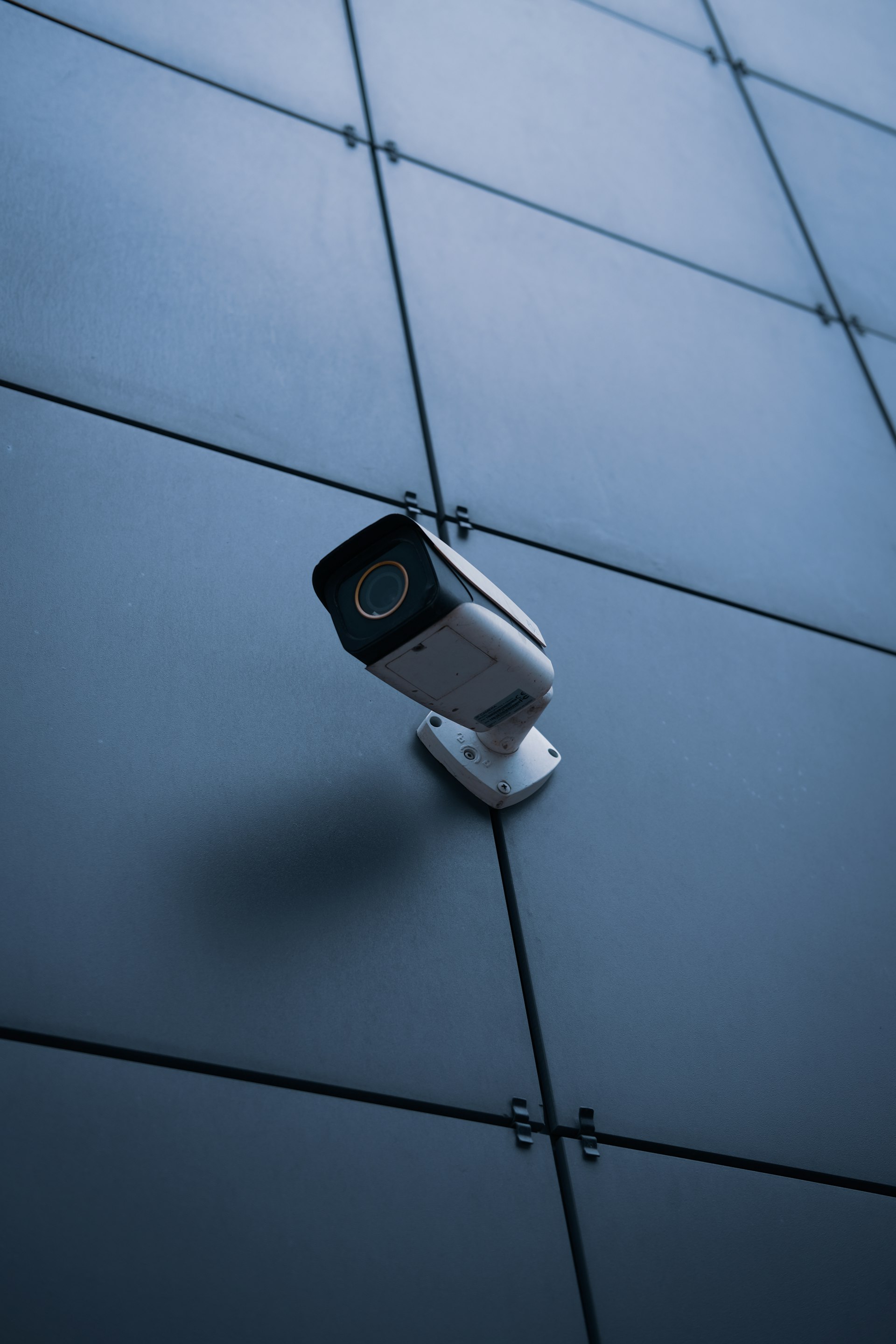 A modern security camera mounted on the exterior wall of a San Mateo home