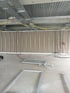 Innenausbau einer Baustelle mit Trockenbauwand, Metallprofilen, freiliegenden Leitungen und am Boden liegenden Fensterrahmen.
