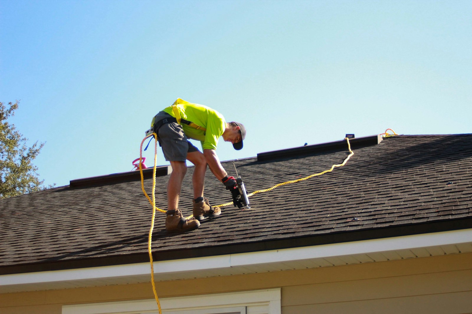 Roofer inspecting the field of an asphalt shingle roof