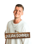 Porträt des Sängers Julian Sommer in weißem T-Shirt vor schwarzem Hintergrund mit Namenszug auf einem Holzschild.
