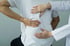Doctor examining lower back, assessing scoliosis and spinal alignment.