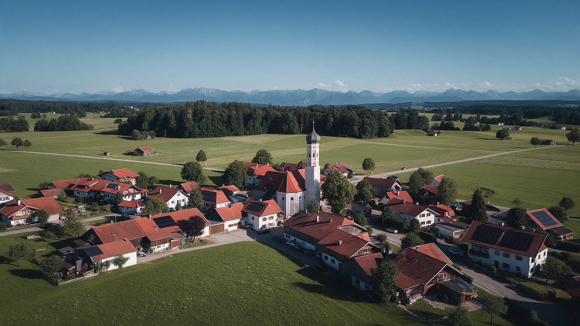 Sauerlach aus der Luft mit Photovoltaikdächern und Alpenblick