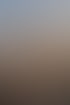 Paar mit Weingläsern auf Dachterrasse bei Sonnenuntergang, Stadtkulisse im Hintergrund.