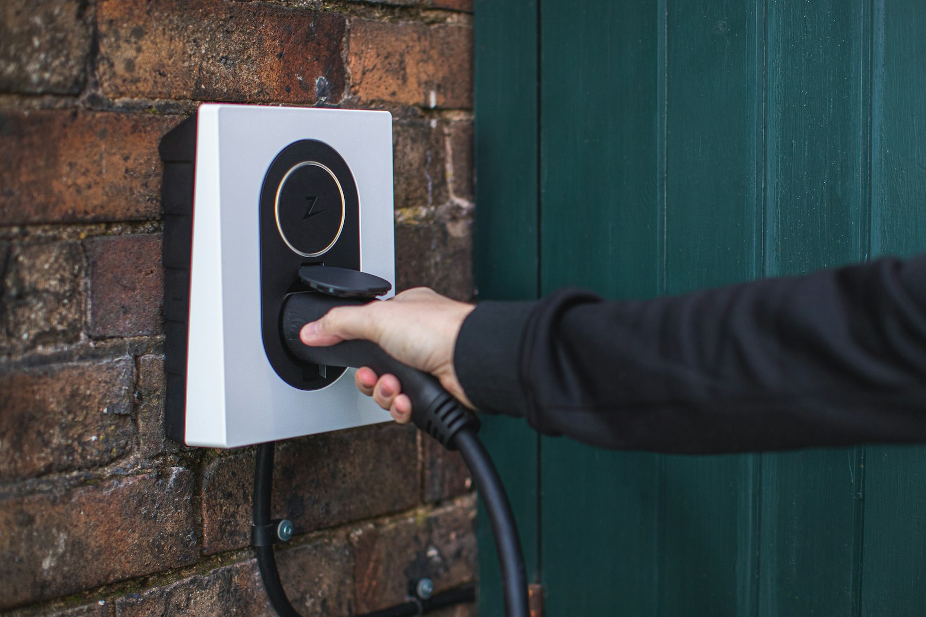 Homeowner plugging into a wall-mounted EV charger in a Yorba Linda garage