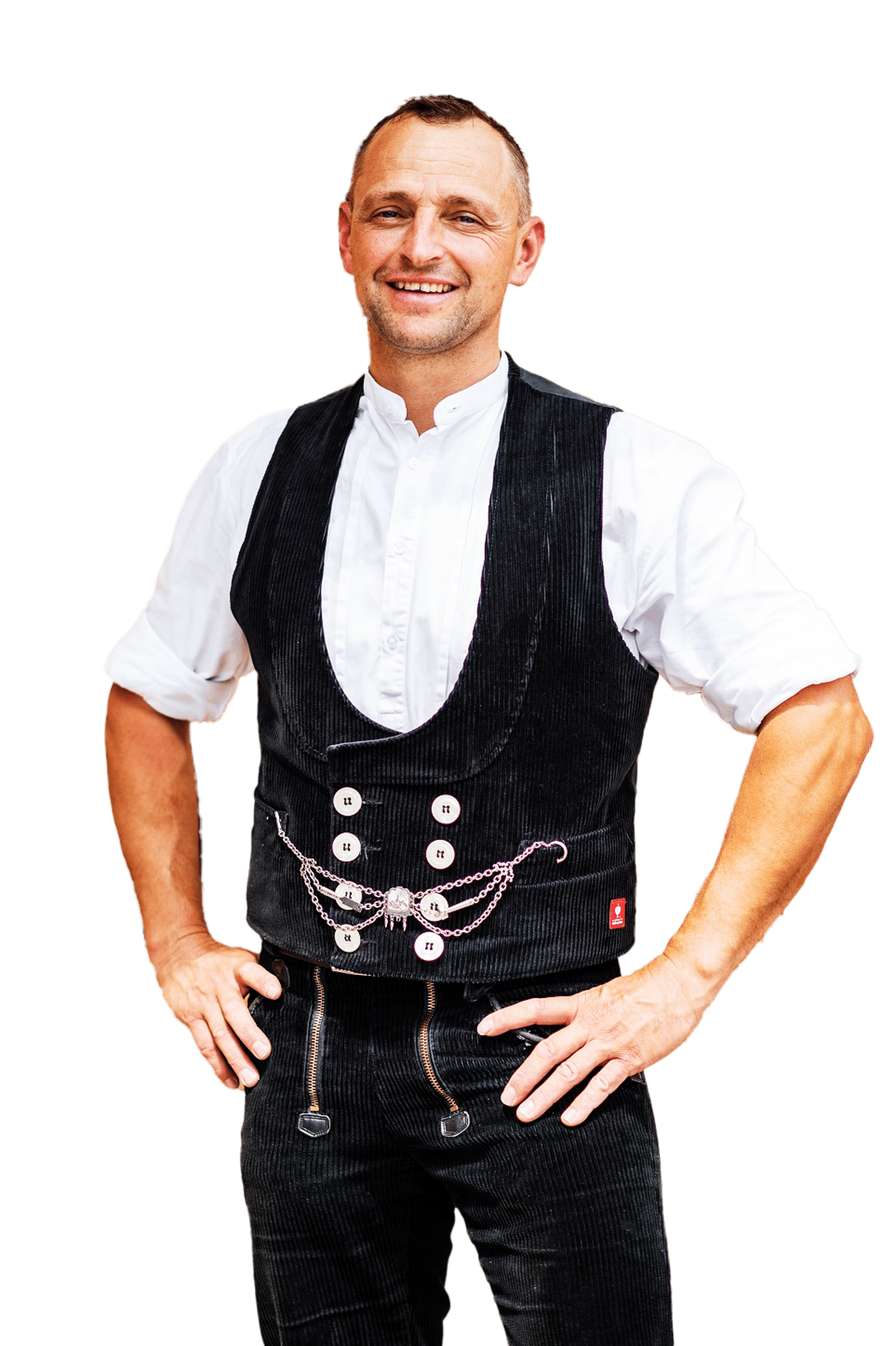 Ein lächelnder Mann in traditioneller Zimmermannskluft mit schwarzer Weste und Hose.