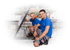 Zwei lächelnde Männer in blauen T-Shirts knien auf einem Dach neben einem Solarmodul.