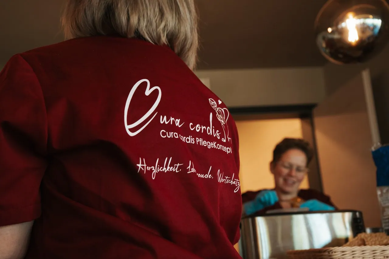 Pflegekraft mit dem CuraCordis-Logo auf dem Rücken