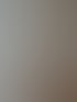 Eine weiße Tür steht offen zu einem Raum mit Holzfußboden und einer Kindersicherung im Türrahmen.