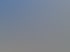 Roter Scania-LKW mit zwei weißen Containern auf einem Auflieger vor einer Berglandschaft.