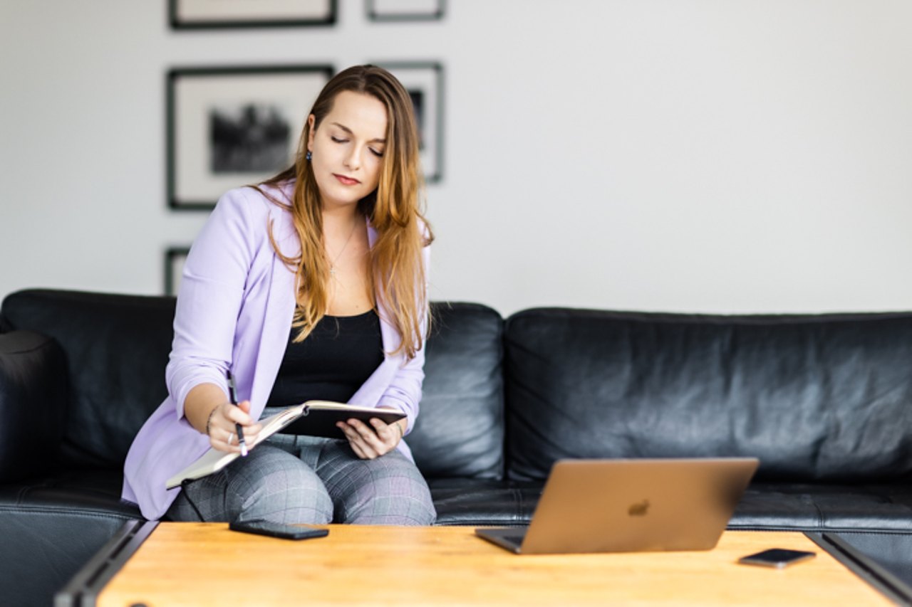 Deborah Vivarelli auf dem Sofa mit Notizbuch und Laptop