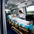 Sanitäterin betreut ältere Patientin auf einer Trage im Inneren eines Krankenwagens.