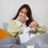A young woman blowing her nose with a tissue, experiencing allergy symptoms.