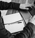 Schwarz-Weiß-Foto: Person arbeitet am Laptop mit Notizbuch und Stift – professionelle Bedarfsanalyse für Handwerksbetriebe zur Neukunden- und Mitarbeitergewinnung.