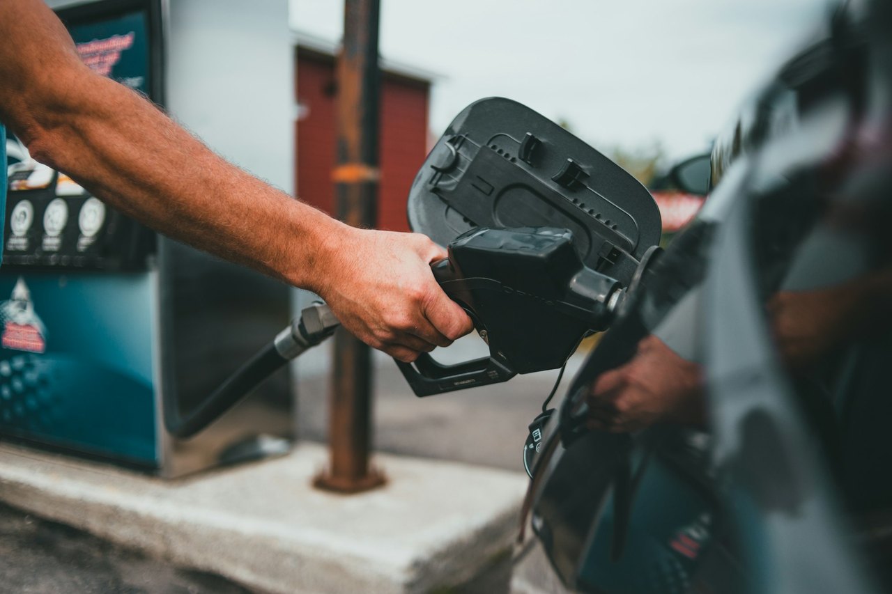 A driver holding a fuel nozzle at a pump island, the moment wrong fuel in the tank begins for Hanford, California drivers