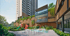 A modern building with wood paneling, green plants, a colorful playground, and a water play area with jets.