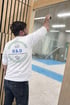 Ein Mann in einem weißen T-Shirt mit dem Logo "D&D REINIGUNG UND GARTENSERVICE" reinigt eine Glaswand.